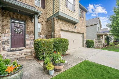 Doorway to property with a garage, concrete driveway, and brick siding