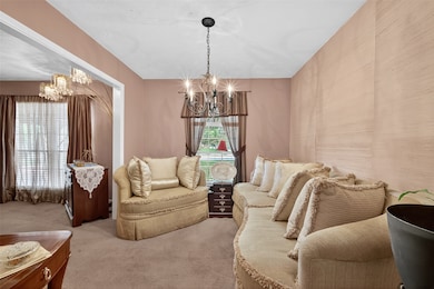 A beautiful living room highlighted by an elegant chandelier creates a warm and inviting centerpiece for the home.