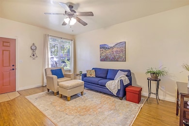 Living room featuring light wood-style floors and a ceiling fan