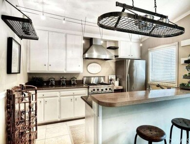Kitchen features granite counter tops, pot racks, 