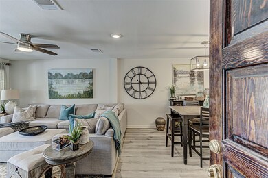 Living area with light wood-style floors, recessed lighting, and a ceiling fan