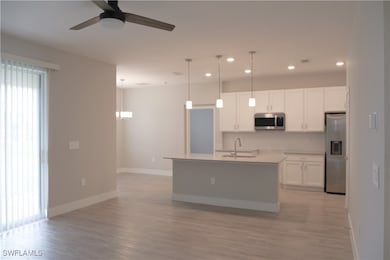 Kitchen with a sink, hanging light fixtures, stain
