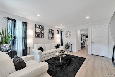 Living room with light wood-type flooring and rece