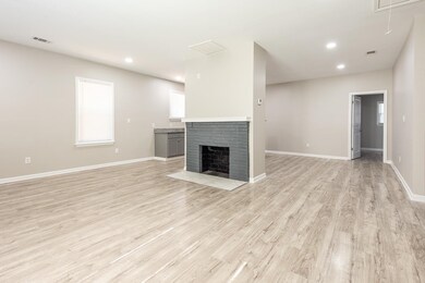 Unfurnished living room featuring a brick fireplac