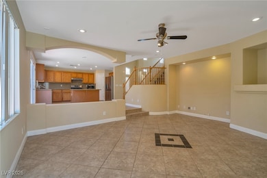 Unfurnished living room featuring stairs, light ti