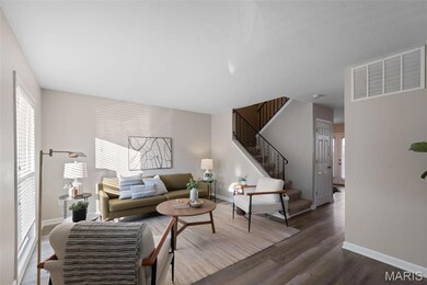 Living room with stairs, healthy amount of natural light, and wood finished floors
