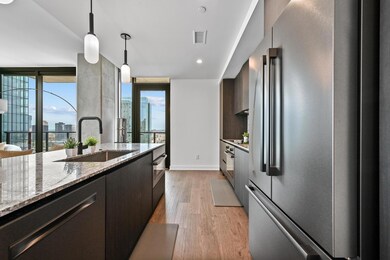 Kitchen featuring high end fridge, a sink, light 