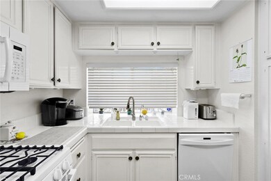 Windows and white cabinetry bring so much light into this space and make it a joyful place to cook while visiting with family and friends. - Open to family room