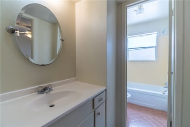Full bathroom featuring vanity, toilet, tile patte