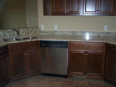 Kitchen with granite counter tops, cherry cabinets, stainless steel sink and tile floors.
