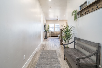 Hall with light wood-style floors and recessed lighting