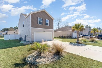 View of front of home featuring a garage, central AC, and a front yard