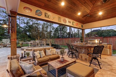 Expansive custom deck features a sitting area, bar, and outdoor kitchen. Attached to this structure is a separate pool house (currently set up as a gym) and full bathroom. Notice the elevated dining space in the distance.