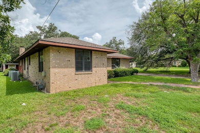 View of side of home with brick siding, a chimney