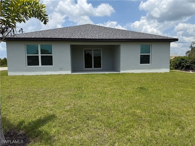 Rear view of property with a yard, a shingled roof