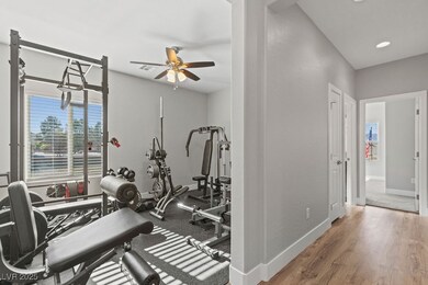 Workout area with ceiling fan, baseboards, and woo