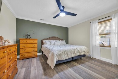 Bedroom with a textured ceiling, light wood-type f