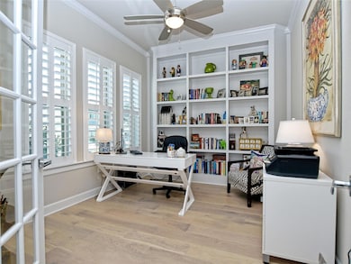 Office area with crown molding, a ceiling fan, an