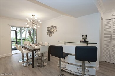 Dining room with crown molding, wood finished floo