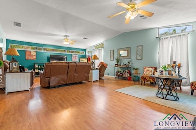 Living area with visible vents, vaulted ceiling, a