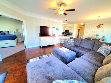 Living room with dark wood-type flooring, crown mo
