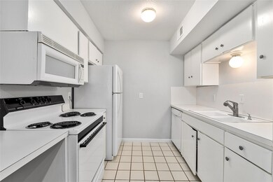 Kitchen featuring white cabinets, light counterto