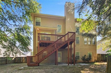 Back of house featuring a fenced backyard, stairs, a chimney, and a patio area