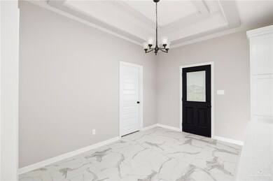 Tiled entryway with a chandelier and a raised ceiling