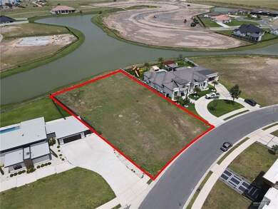 Aerial view of residential area with a large body of water and property parcel outlined
