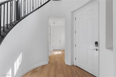 Foyer with baseboards, stairway, and light wood-ty