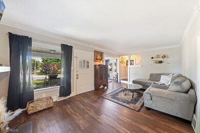 Living room with ornamental molding and dark hardwood / wood-style floors