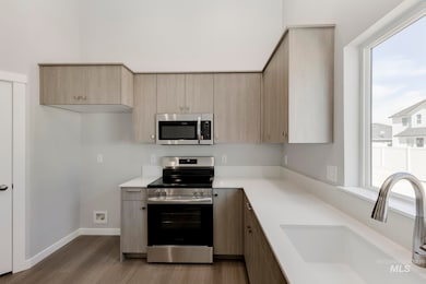 Kitchen with stainless steel appliances, plenty of natural light, modern cabinets, and dark wood-style floors