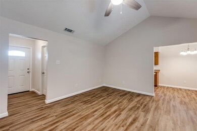 Spare room with wood-type flooring, vaulted ceiling, and ceiling fan with notable chandelier
