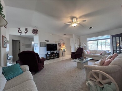 Living room with a ceiling fan and lofted ceiling