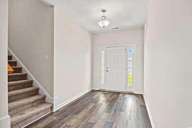 Entryway featuring dark wood-style floors, stairs, and baseboards