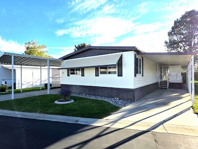 View of side of property with a carport, driveway, and a yard