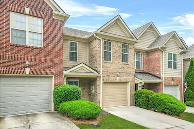 Traditional home with an attached garage, concrete driveway, brick siding, and a shingled roof