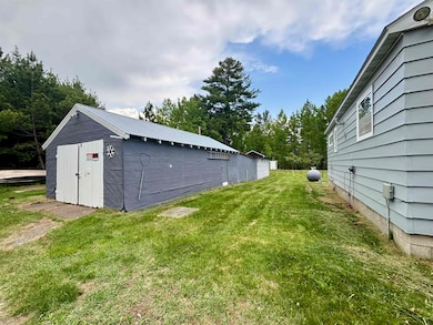 View of grassy yard with an outbuilding