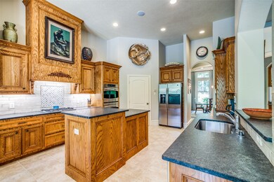 Spacious island kitchen with leathered countertops and an abundance of cabinet space.