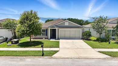 Single story home featuring driveway, a front lawn, and a garage