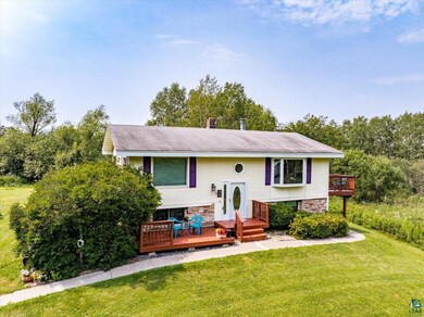 Raised ranch featuring a deck and a front lawn