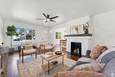 Living area with wood finished floors,  a ceiling fan, and a fireplace