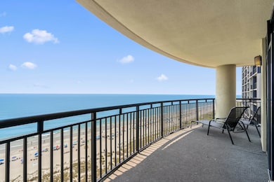 Balcony featuring view of water and beach