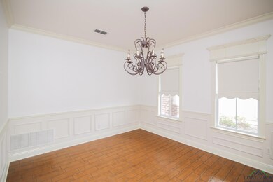 Empty room featuring ornamental molding, hardwood / wood-style flooring, and an inviting chandelier
