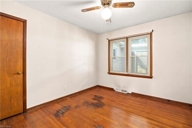 Wood floored spare room featuring ceiling fan