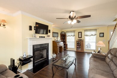 A fireplace and ceiling fan complete this family room,
