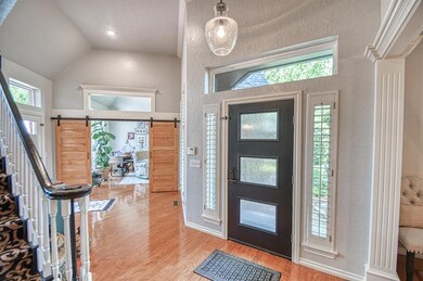 Entrance foyer featuring high vaulted ceiling, woo