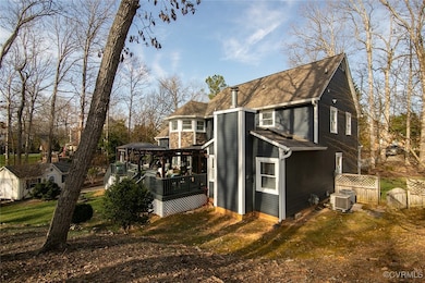 View of side of home featuring a gate, central AC,