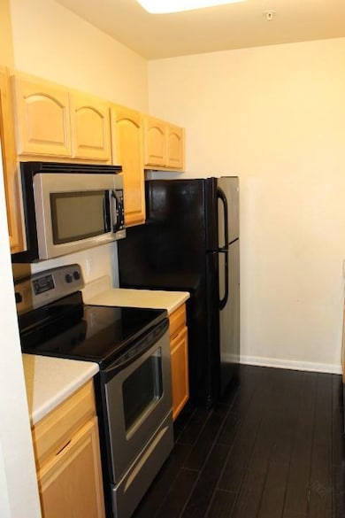 Kitchen with stove, light brown cabinetry, light 