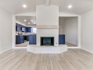 Unfurnished living room with baseboards, light woo